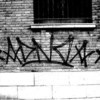 pared de maó en blanc i negre amb un graffitti