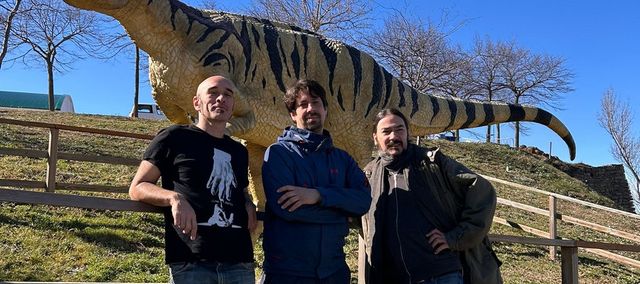 foto dels integrants de tiznao davant d'una estàtua d'un dinosaure